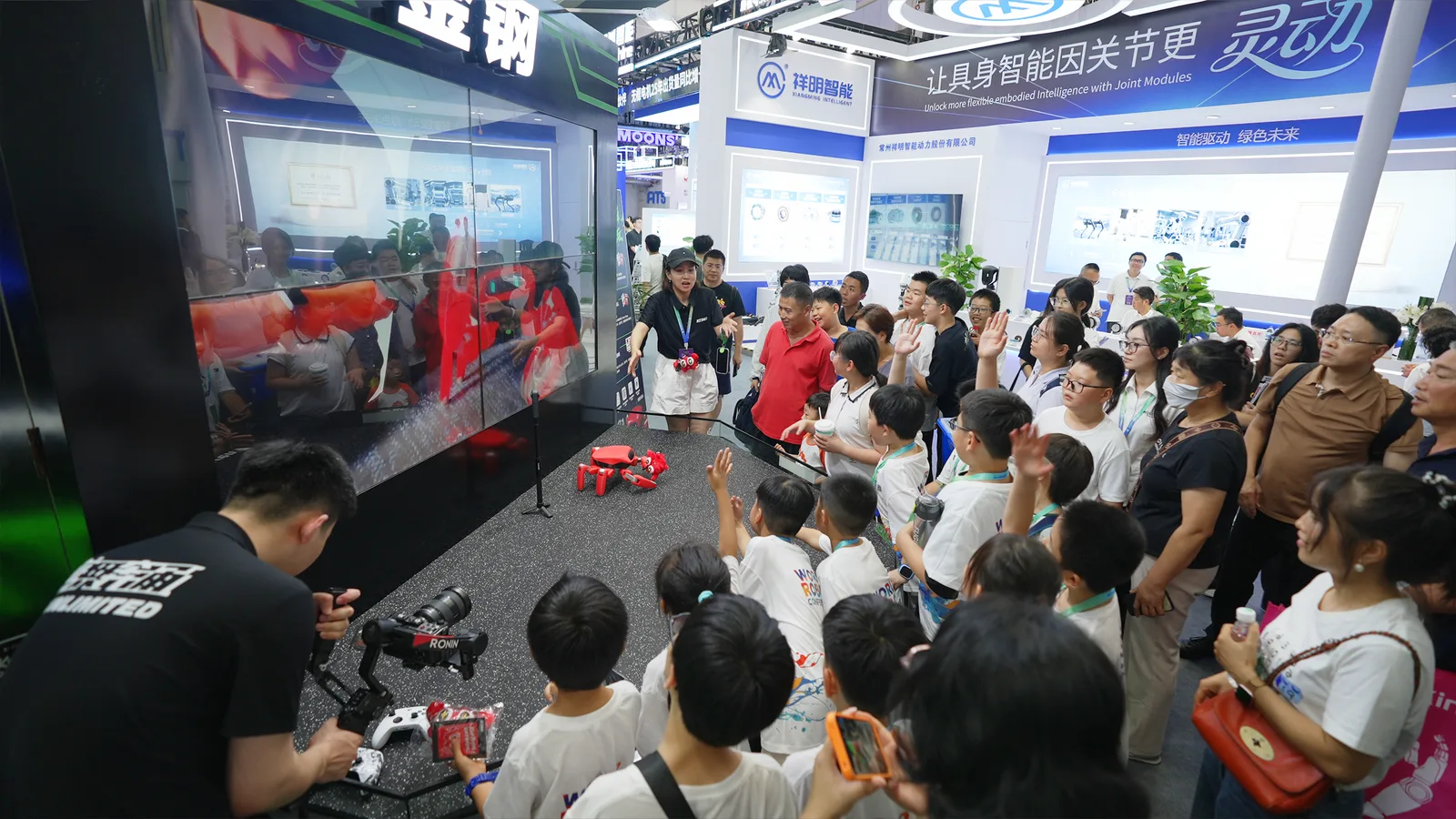 世界机器人大会金钢科技展台，观众围观螃蟹机器人互动